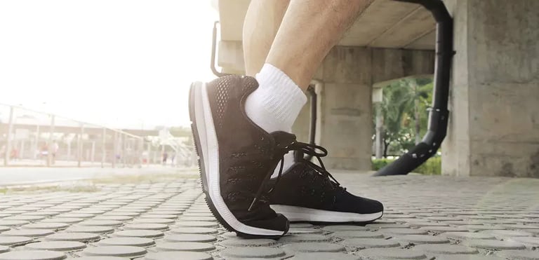 artrosi-di-caviglia-piede-dello-sporitvo-scarpa-nera-min