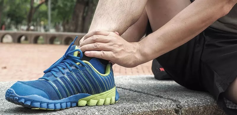 Foto di un runner con una caviglia indolenzita.