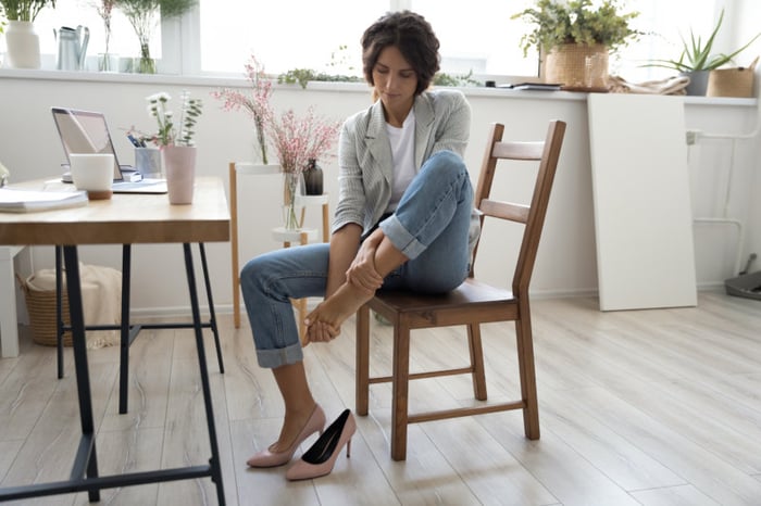 Foto di una donna con dolore alle dita dei piedi.