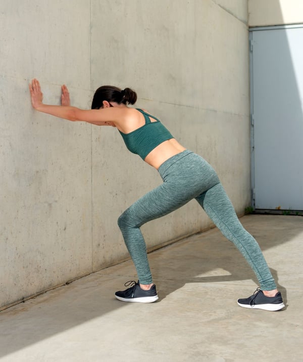 Foto di una donna che esegue l'esercizio di stretching del tricipite surale.
