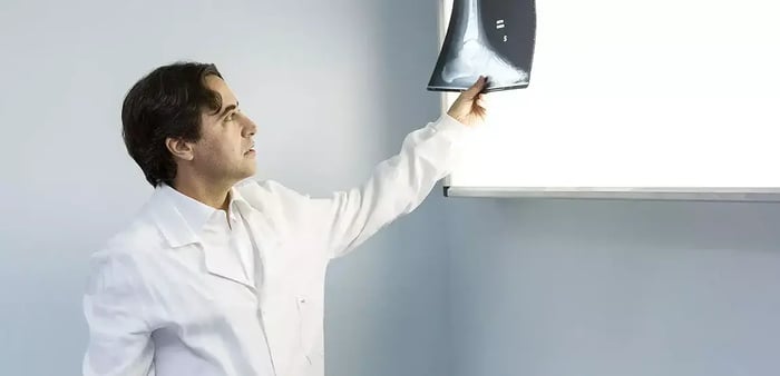 Foto del dr. Usuelli che esamina la radiografia di un piede.