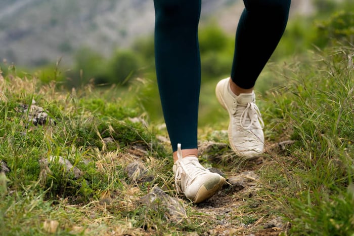 Foto di una donna con una caviglia che cede camminando su terreni irregolari.