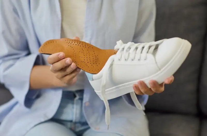 Un plantare per alluce rigido viene inserito in una scarpa comoda.
