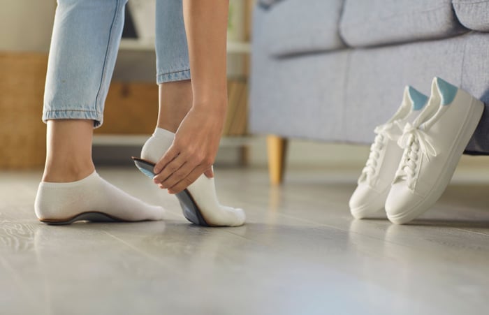 Foto di una donna che prova dei plantari ortopedici.
